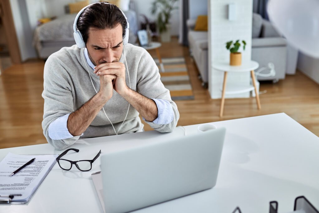 young worried businessman using computer reading email while working home